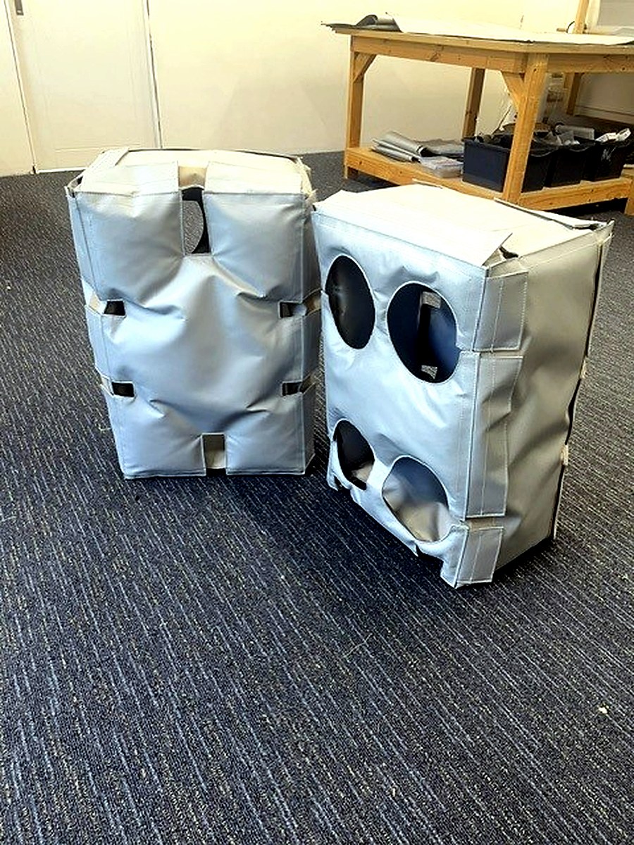 Two fabricated thermal jacket enclosures in a workshop before site installation